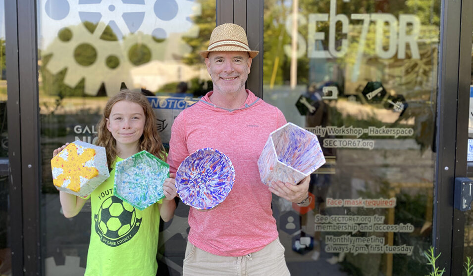Hollis and Isaac Nadeau show off some of the colorful items they've made using recycled plastic they procured.
