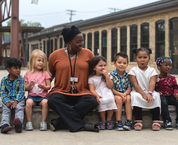 Goodman Center CEO Letesha Nelson sits with a group of preschoolers