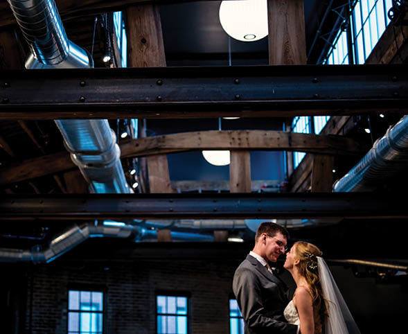 A bride and groom in a dark wedding venue with beautiful lighting