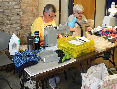 Goodman Menders fix clothes for attendees of the Fritz Food Pantry.