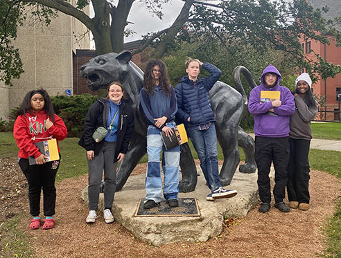 GCC teens stand in front of a statue of a panther at the University of Wisconsin-Milwaukee.