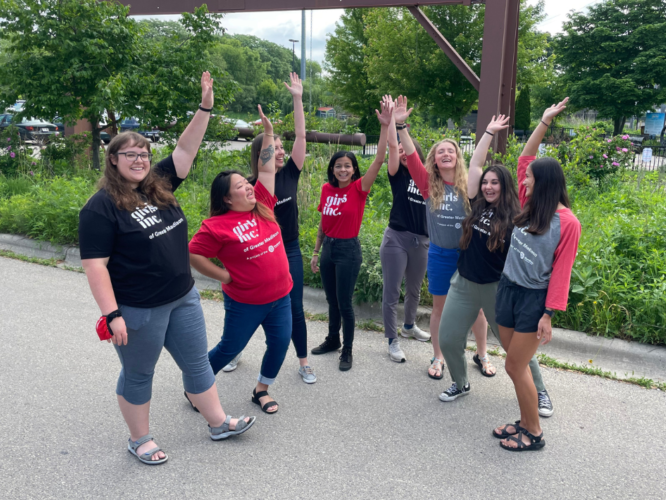 Girls Inc. of Greater Madison summer 2022 staff lift their arms in excitement.