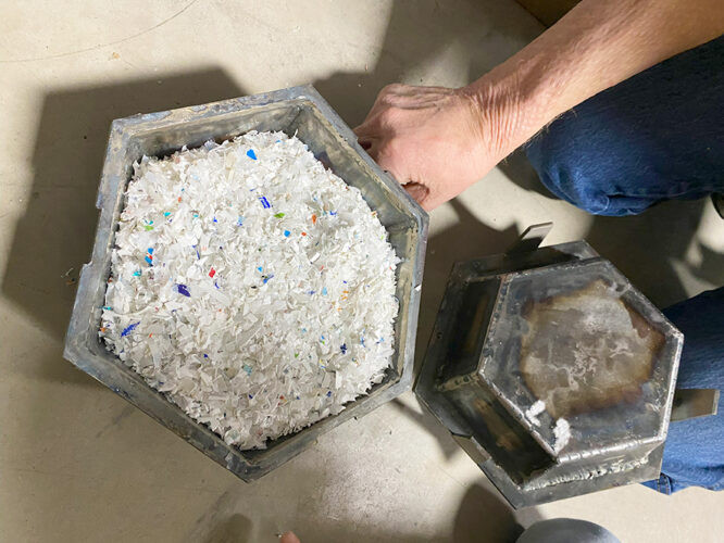 The mold for bowls is filled with shredded plastic as the transformation begins into something useful..