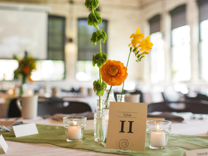 Flowers, table numbers, and decorations set up on a table in an event space