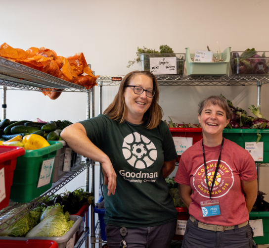 Food pantry staff pose in front of the pantry's produce stand.