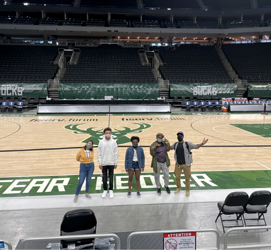 Students and staff pose on the Milwaukee Bucks basketball court. They took a field trip to tour the Fiserv center.
