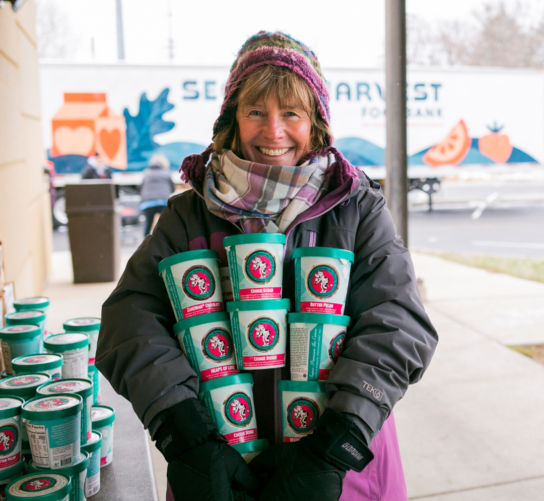 A volunteer holds pints of Chocolate Shoppe Ice Cream at the Goodman Center Thanksgiving Basket Drive.