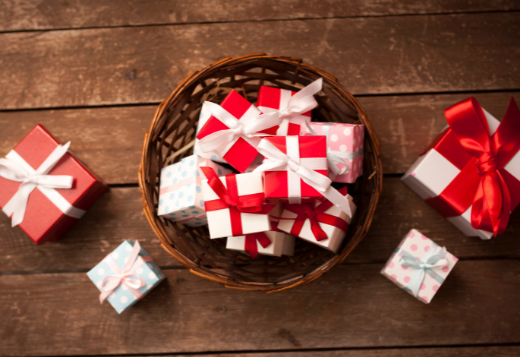 A pile of red and white wrapped gifts in a basket.