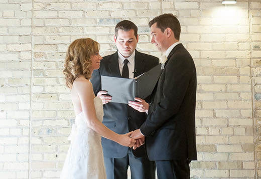 A bride and groom with a wedding officiant