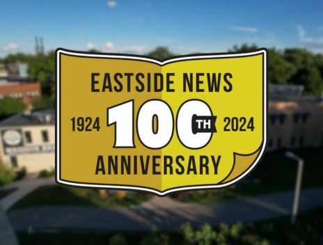 The 100th Anniversary Logo for Eastside News is placed on top of an arial shot of Brassworks on a sunny day.