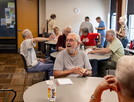 A group of older adults happily playing Euchre together.